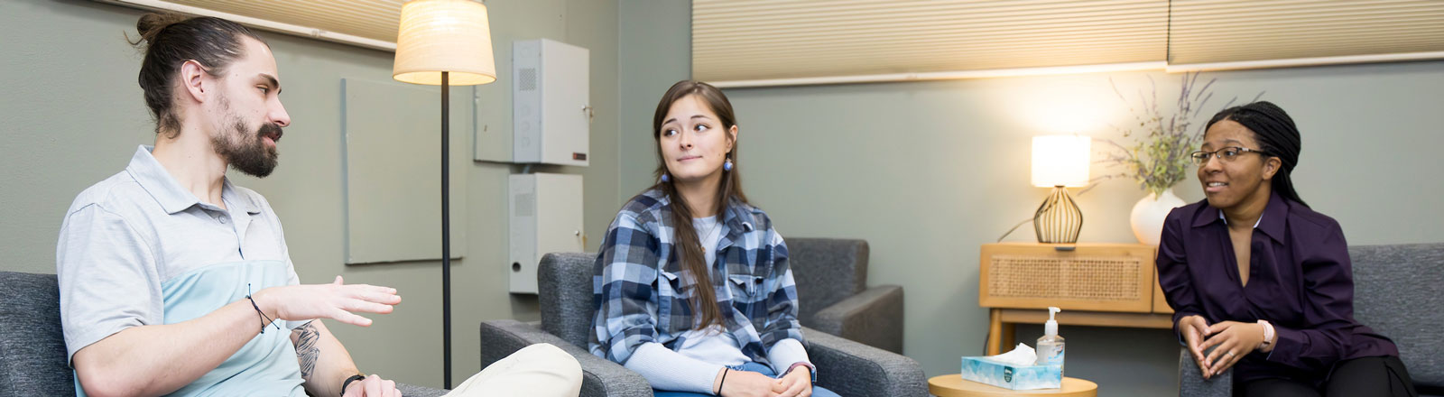 Three counseling students talking to one another in a room..