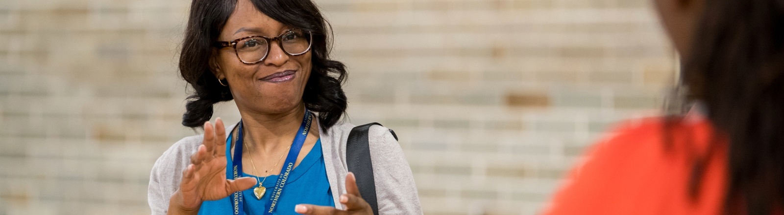 A POC individual in conversation with another individual