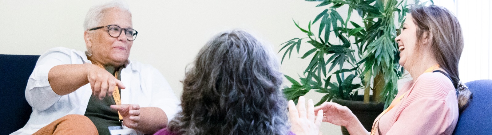 Three individuals communicating in sign language