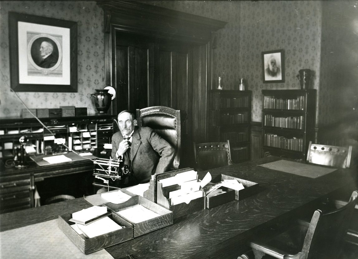 Photo of President Zachariah Xenophon Snyder sitting behind a long conference table in Normal School Building