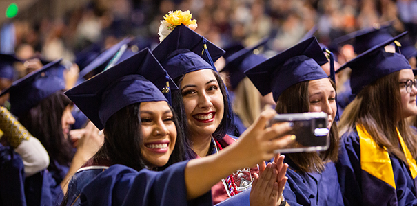 Two Latina women taking a self portrait at graduation