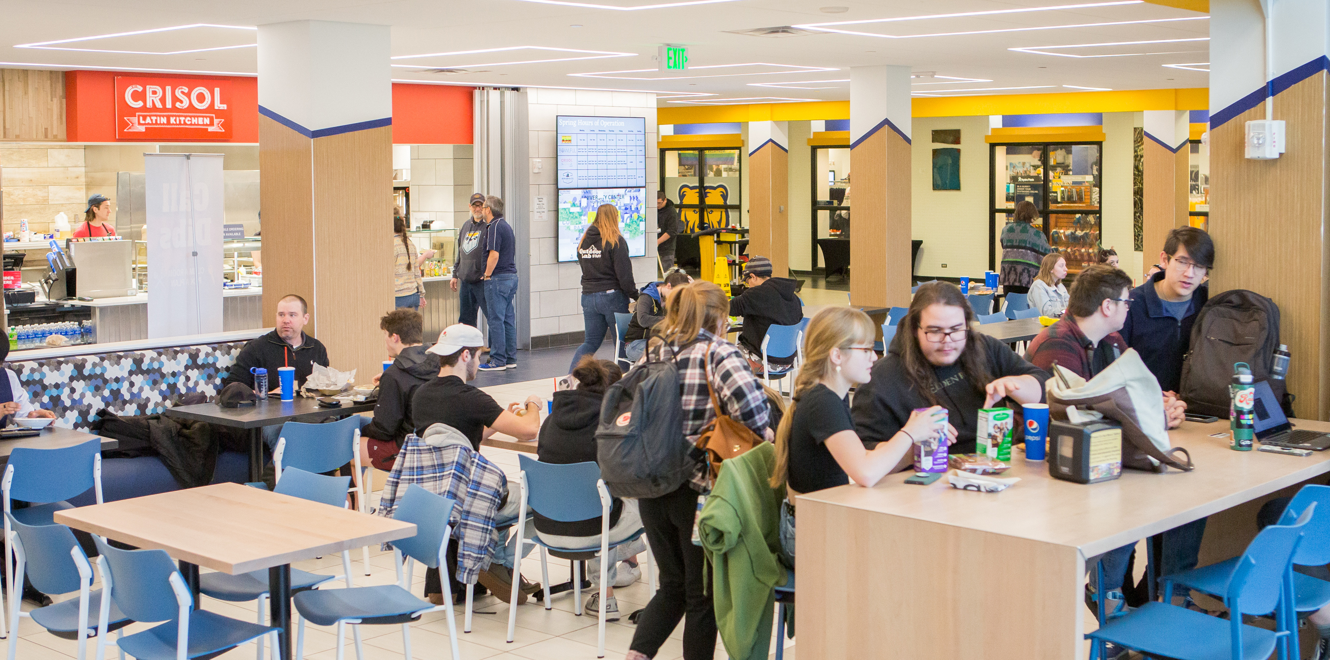students sitting at tables eating together in new food court