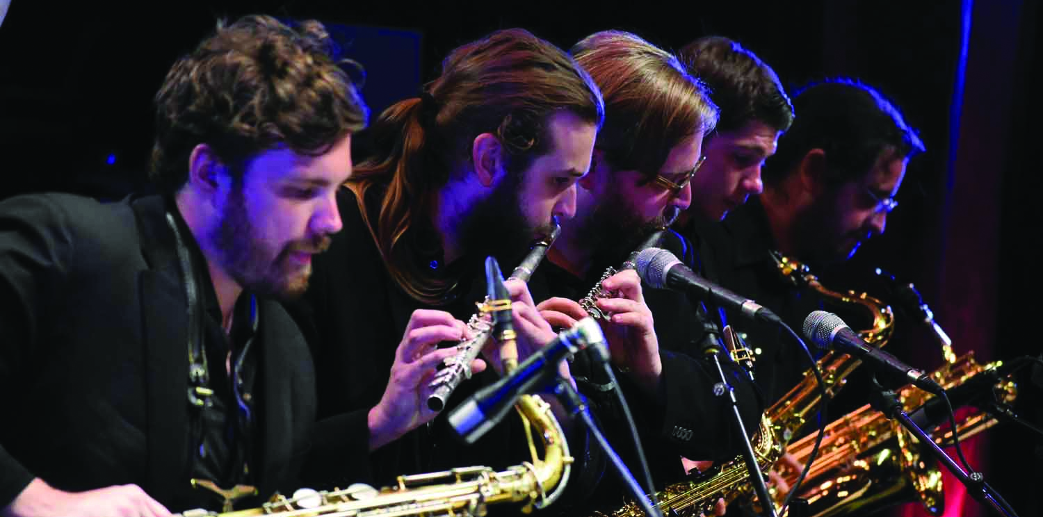 UNC performers playing saxophone and flute on stage