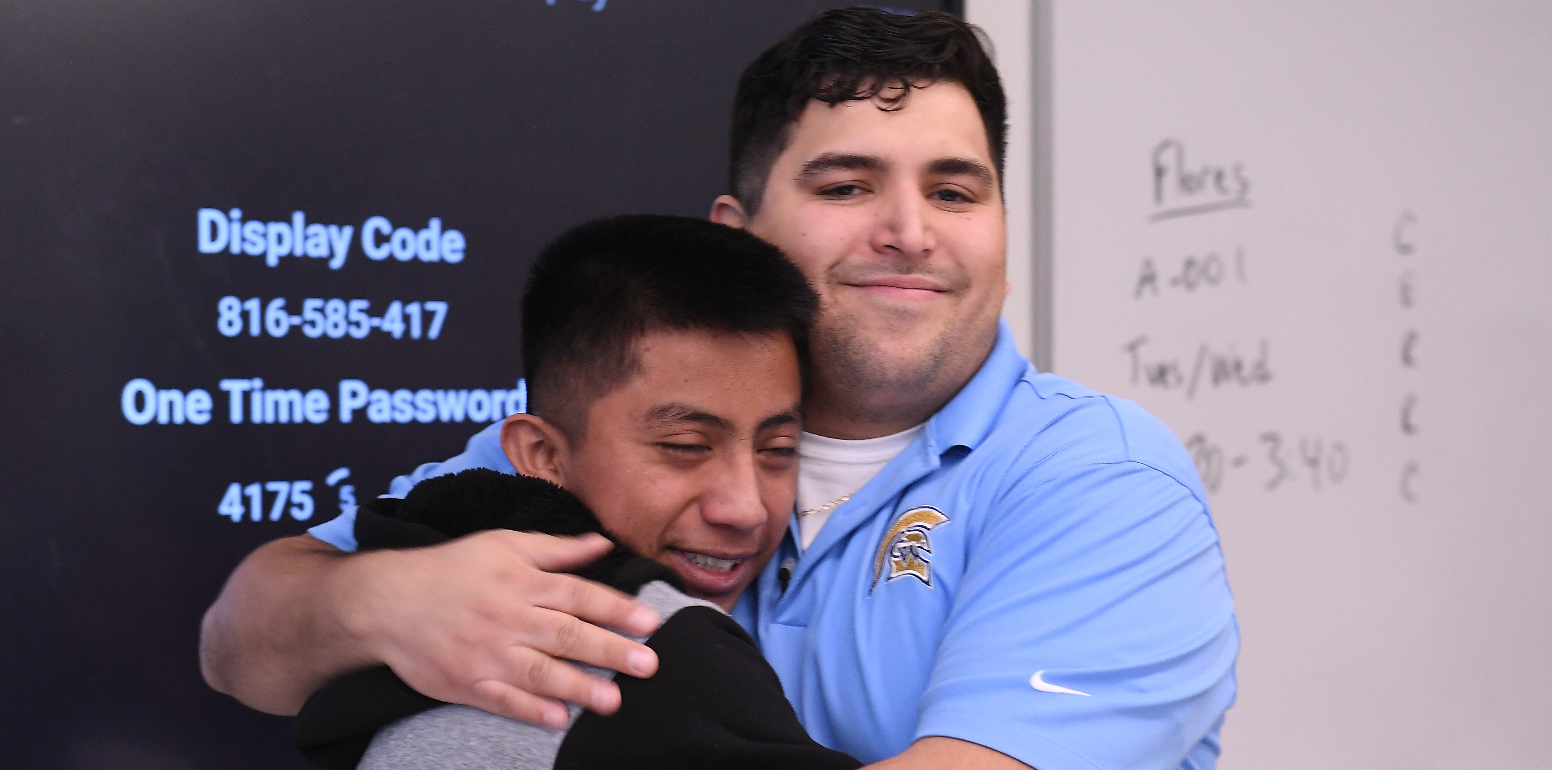 Caleb Flores abrazando a uno de sus alumnos