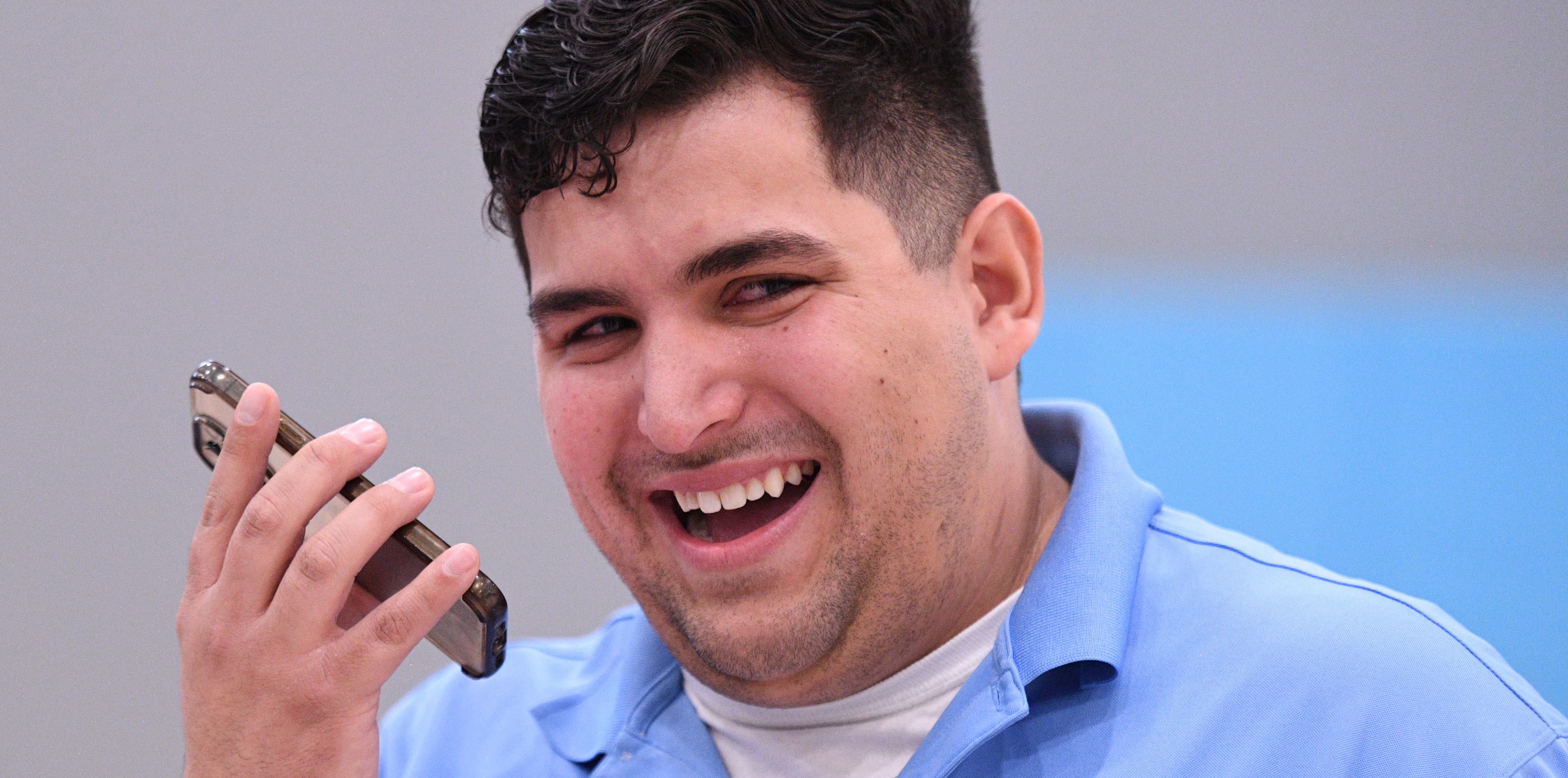 Caleb Flores sonriendo con un celular en mano