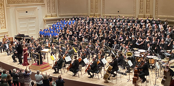 musicians and performers on stage at Carnegie Hall in front of audience giving standing ovation