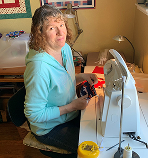 Julia Riley sitting at her sewing machine