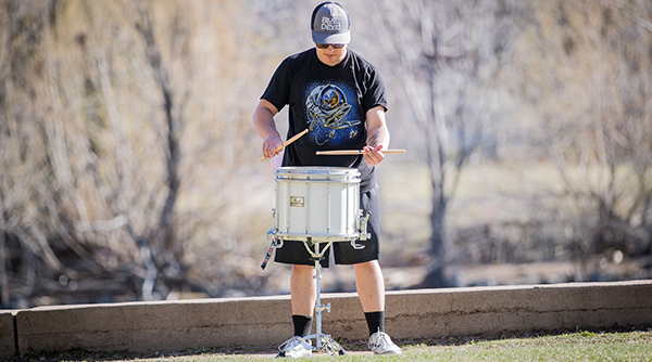 Student playing drums outside