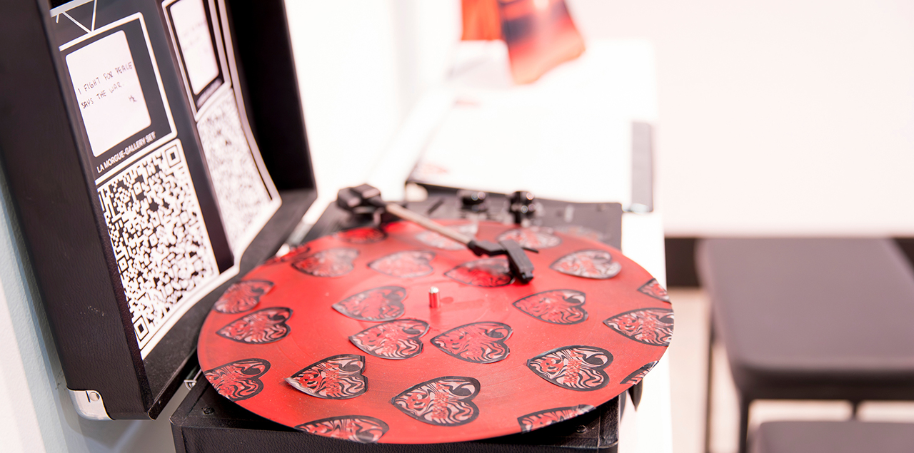 Record player with the needle down on a record covered in hearts