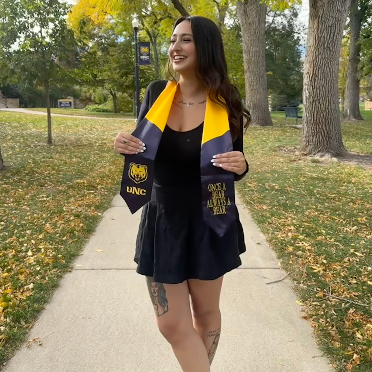 Haley wearing her UNC graduation gown outside and smiling