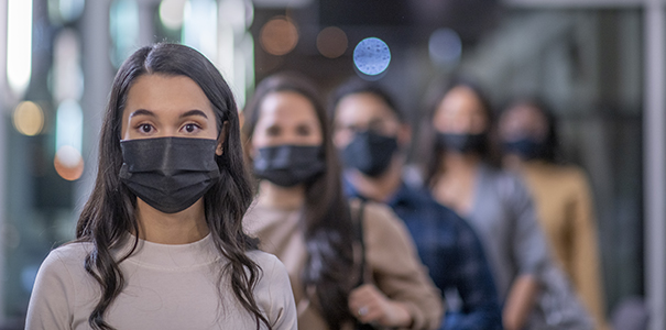 College students standing in a hallway wearing face masks