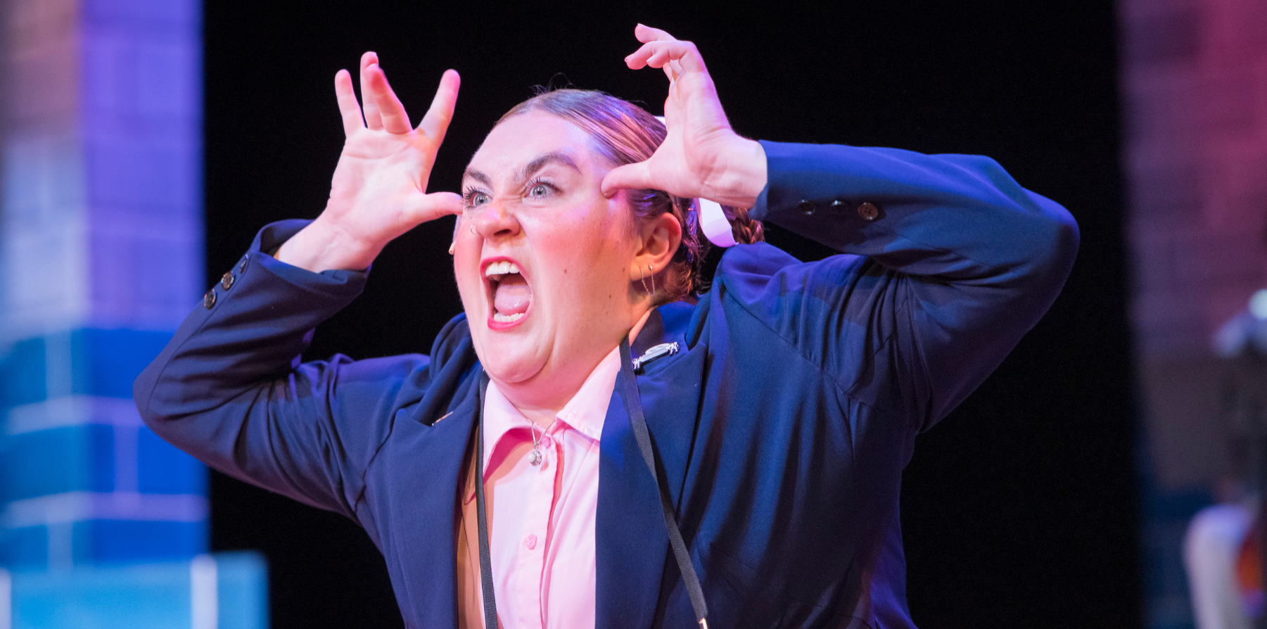 A student actor making a funny face on stage.