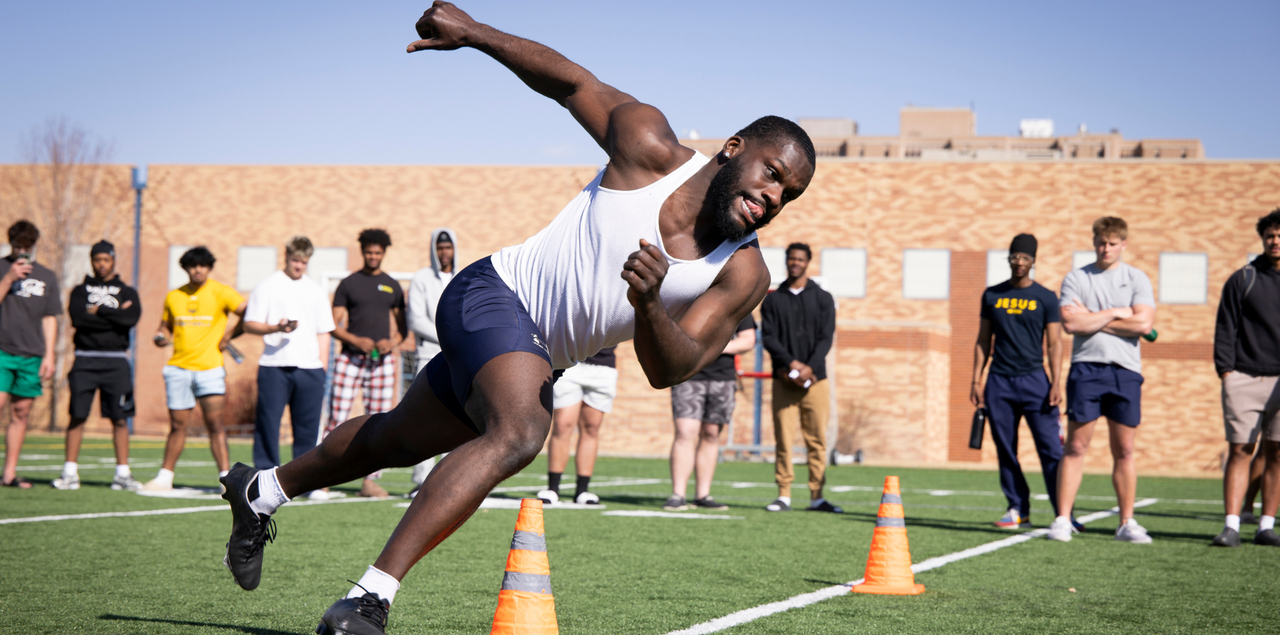 A student athlete running on a football field.