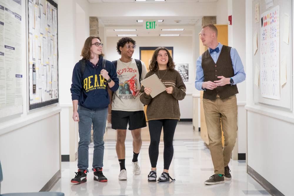 Students walking with professor down math hallway