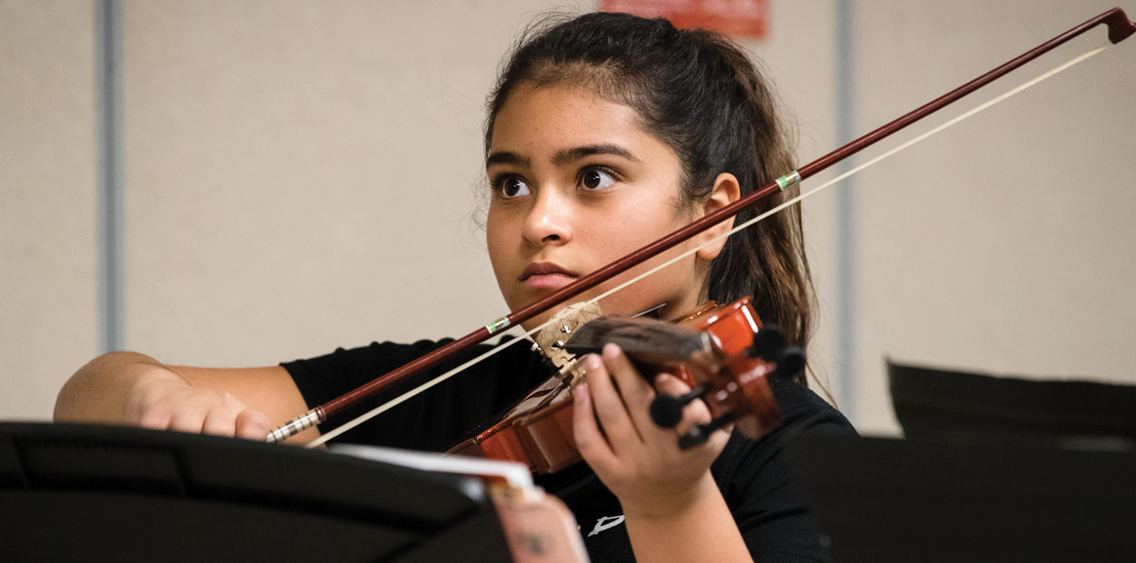 Student playing string instrument