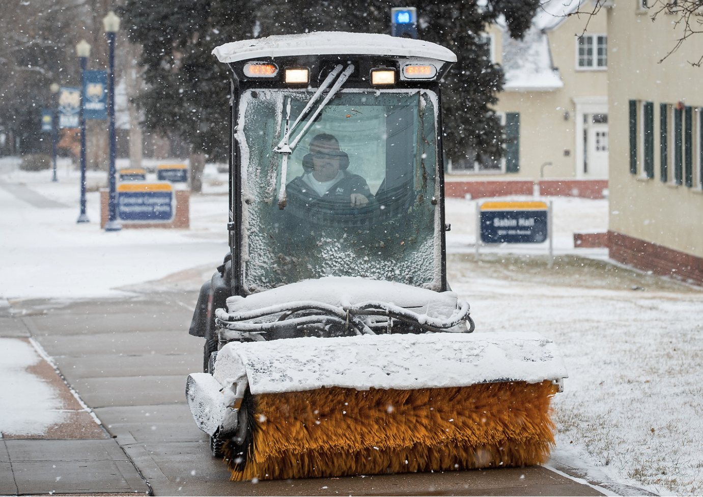 UNC faclitlies member clearing walkways of snow.